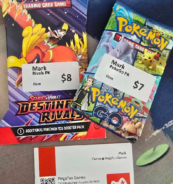 Orbitect review photo showing Pok&eacute;mon packs and MegaFun TCGs business card